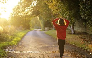 woman in red jumper walking on country path